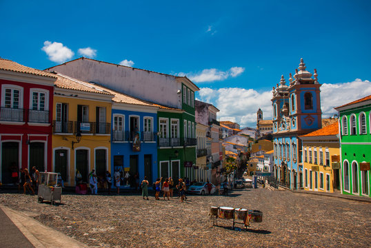 Historic city center of Pelourinho features brightly lit skyline of colonial architecture on a broad cobblestone hill in Salvador, Brazil