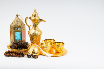 Fototapeta na wymiar Premium dates, lantern and arabic coffee mug on white background. Selective focus, copy space and Ramadan Kareem concept