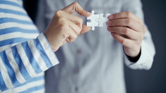 jigsaw puzzle holding by two people hands, together to success concept