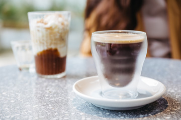 Frothy Nitro Cold Brew Coffee in drinking glass on granite top table with blur background.