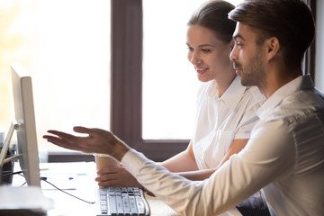 Office workers sitting at desk working together at workplace