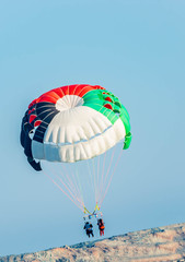 Couples doing paragliding water sport in blue water sea at beach