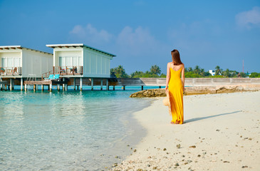 Woman in dress walking on tropical beach