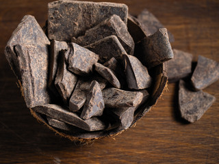 Natural chocolate without sugar from grated cocoa beans, in eco packaging on a dark background