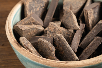 Natural chocolate without sugar from grated cocoa beans, in eco packaging on a dark background