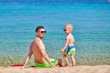 Naklejka premium Toddler boy on beach with father