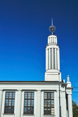 a white, historic modernist building with a tower in Poznan.