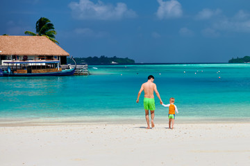 Toddler boy on beach with father