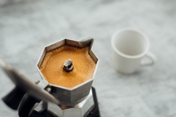 Moka pot with coffee and cup