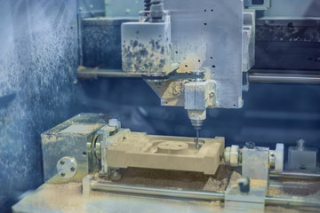 Milling machine cutting wooden workpiece at futuristic technology exhibition. Woodworking, CNC engraving, carving, industrial and manufacturing concept