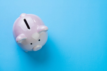 Financial, savings, budget, cost or investment concept, white happy piggy bank on clean blue background with copy space