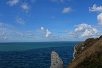 Fototapeta na wymiar Etretat, France. White chalk cliff on the background of the turquoise sea and a blue sky