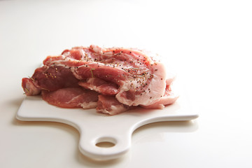 Fresh raw seasoned pork on cutting board 