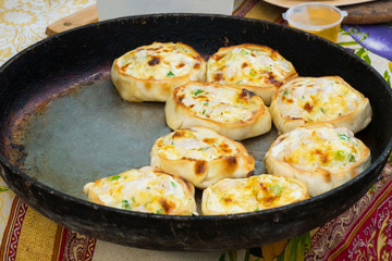 Process of cooking hot mini pies with chicken and cheese at street food festival. Outdoor cooking, service, gastronomy and takeaway food concept