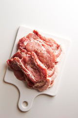 Fresh raw seasoned pork on cutting board 