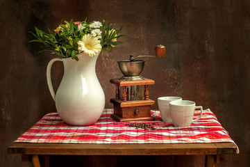 Classic vintage still life of summer bouquet, morning coffee and coffee grinder.