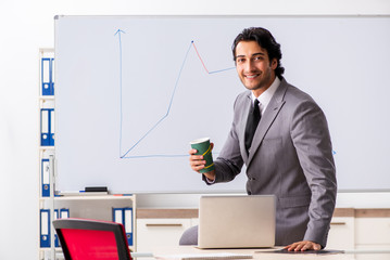 Naklejka premium Young handsome businessman in front of whiteboard 