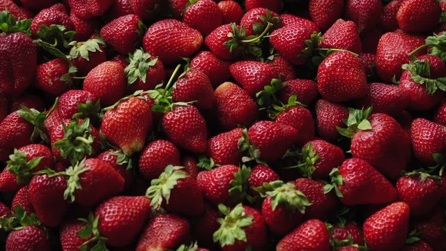 Background top view 4k video of strawberries rotating