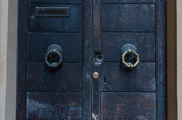 Close up of closed heavy wooden doors with octagon door handle