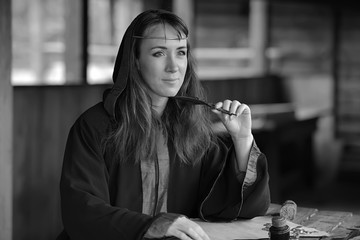 Woman thinking with a pen writing in the hands. Fashion, clerk.
