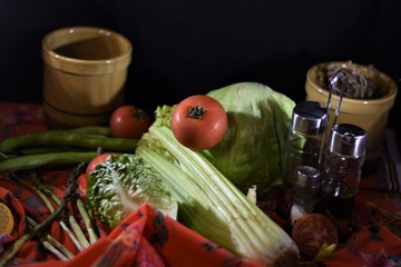 a tomato on the celery and surrounded by other vegetables