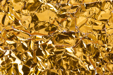 Gold crumpled foil paper texture background.