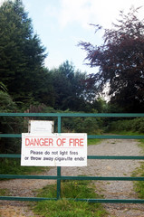 Warning sign on metal gate in woodland - 267383135