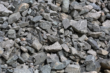 Gray textured surface of a heap of construction pebbles and gravel