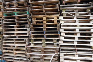 Stacks of old used discarded wooden shipping pallets 