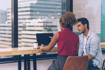 Working woman and man sharing idea about their work in co working place