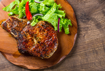 Pork Loin chops marinated meat Steak with vegetables slad on wooden table background