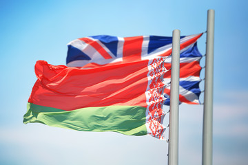Flags of Belarus and UK against the background of the blue sky