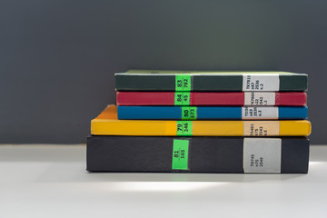 Books stacked on the table in library at university in selective focus.