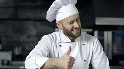 Chef man posing at professional kitchen. Professional chef with thumbs up