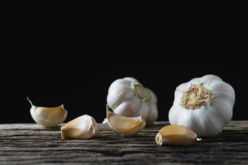 Closeup garlic on wooden texture on for cooking on dark background