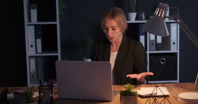Businesswoman having late night video call at office
