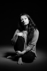 Wundersch&ouml;nes schwarzhaariges Model in schwarzwei&szlig; im Studio mit Brille, Pullover und Stiefel