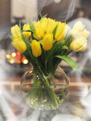 Fototapeta na wymiar A bouquet of yellow tulips in a vase in the interior of a retro room. Retro interior with bouquet of tulips.