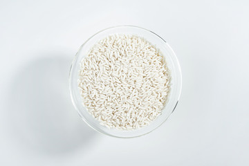 Glass bowl filled with a bowl of white glutinous rice on a white background