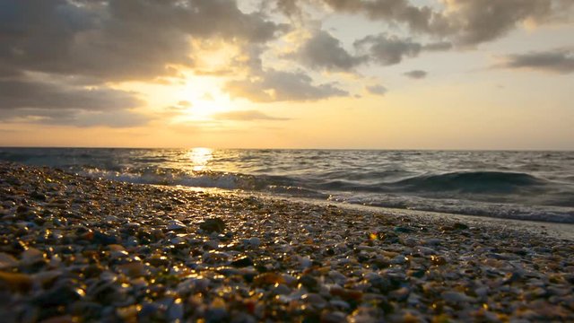 Beautiful sunset at ocean beach - nature waves on shells and sand backgrounds