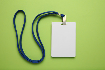 Empty name tag with white strap, mockup on green background.