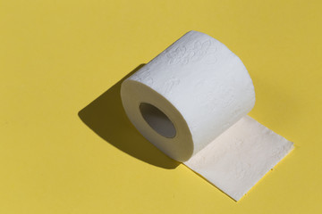 Roll of toilet paper or tissue isolated on yellow background. close up photo. copy space