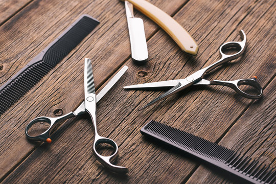 Barber tool. Barber scissors. Scissors, razor and hairbrush on vintage wooden background.