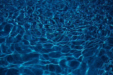 Ripple blue water in swimming pool of resort hotel with sun reflection. Summer holiday concept,...