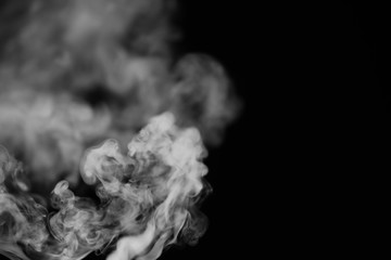 White smoke on a black background. Texture of smoke. Clubs of white smoke on a dark background for an overlay