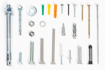 Top view of assorted materials carpenters use  like screws, bolts, fixings, nuts screws and nails on a white background.