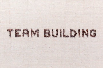 The words Team Building written with coffee beans, aligned in the center,close up.