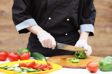 The cook cuts fresh farm vegetables