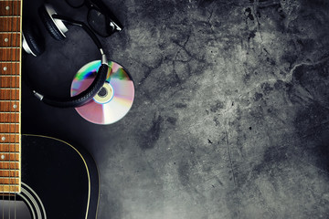 Guitar and accessories on a stone background. Desk musician, headphones, microphone.