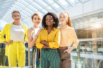 female boss of company in stylish clothes posing with arms crossed in front of the team. close up photo. copy space.